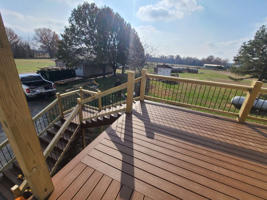 New composite deck and railing seen from above, overlooking a farm field