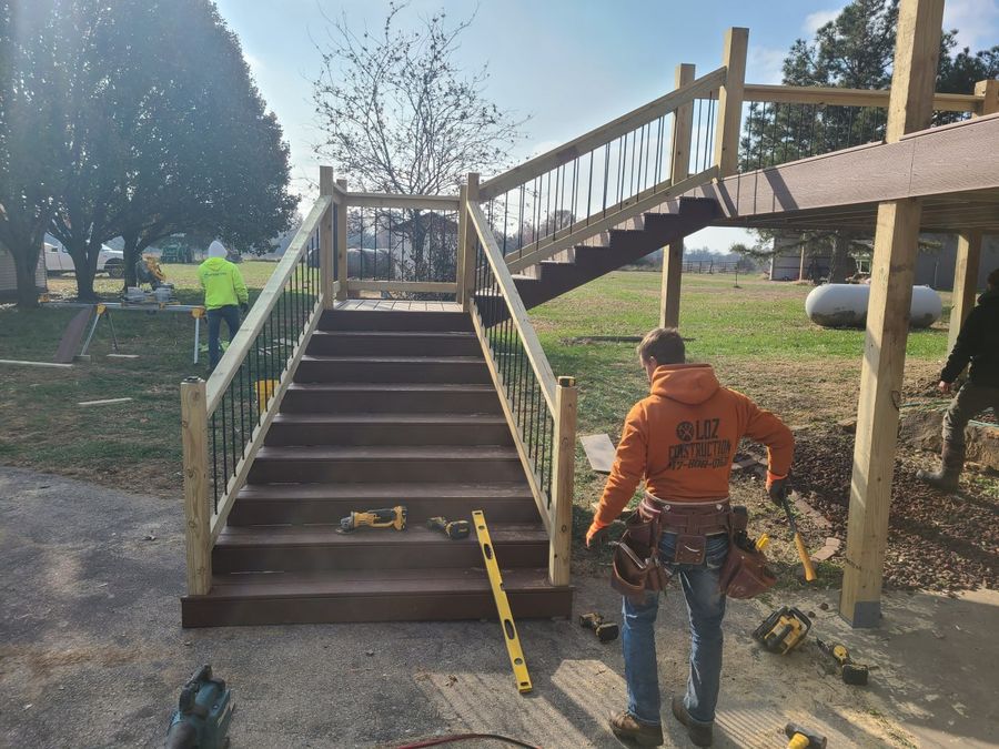 L.O.Z. Construction crew member in a company hoodie finishing new composite deck stairs