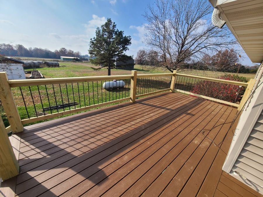 Finished composite deck with black baluster railings overlooking a Missouri field