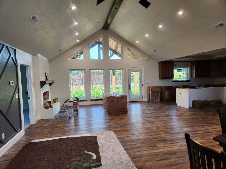 Vaulted great room with triangle windows, exposed beam and an oak kitchen beyond