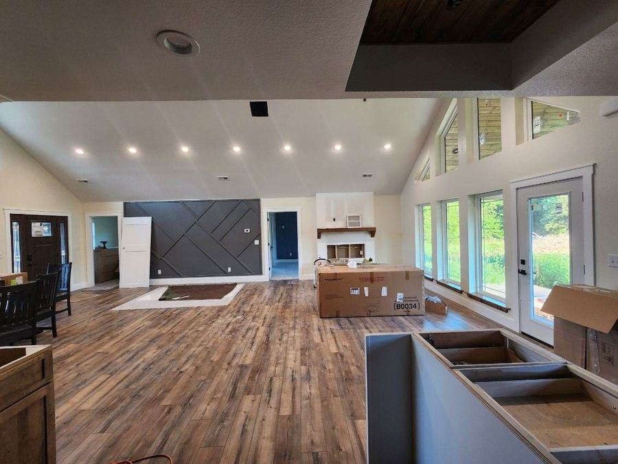 Great room with a gray geometric trim accent wall, tall windows and wide-plank flooring