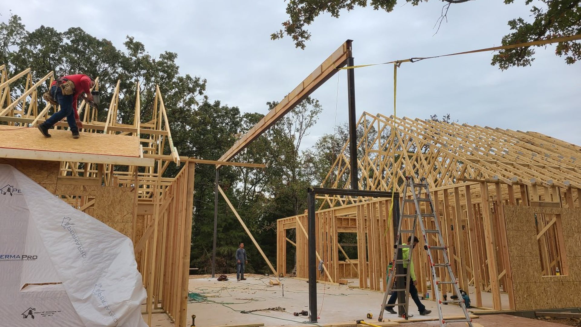 Steel beam and roof trusses being set by the L.O.Z. Construction framing crew