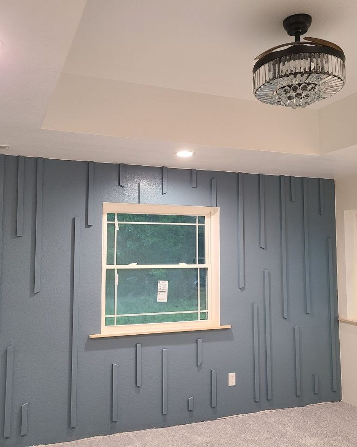 Finished blue accent wall with vertical trim pieces, the kind of finish carpentry we do inside