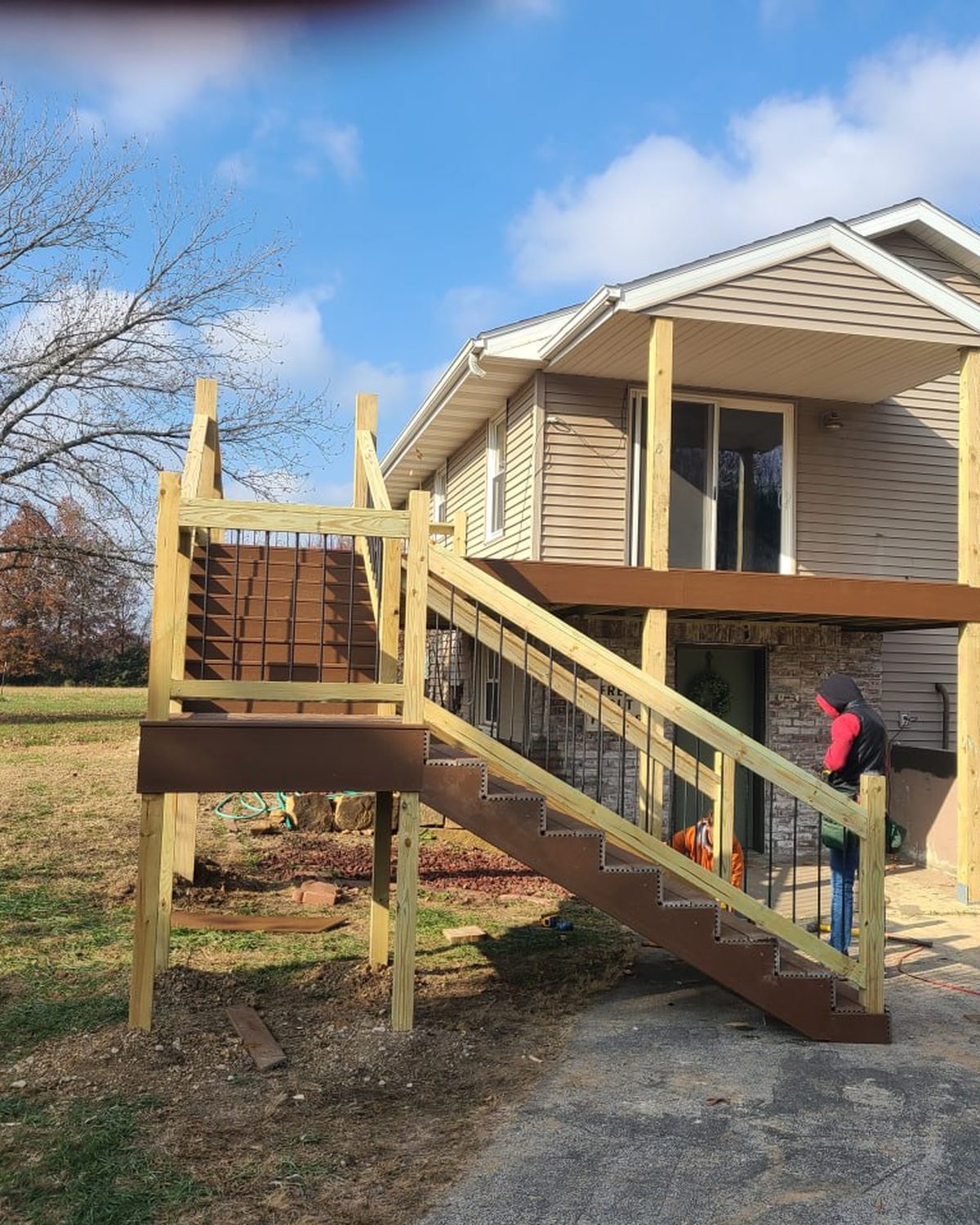 New deck stairs and railing going up on a rural home with the L.O.Z. crew on site